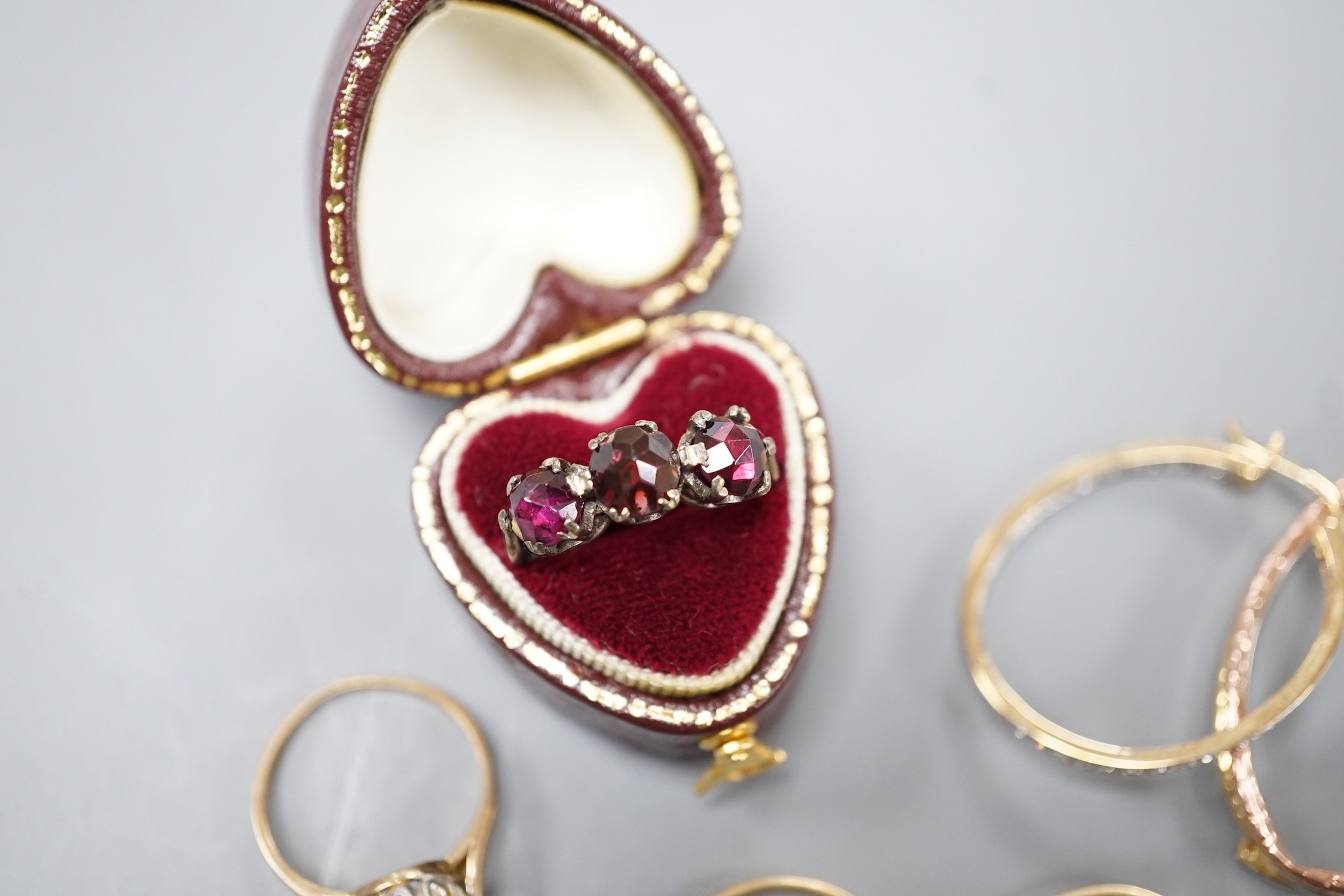Six assorted modern 9ct gold and gem set rings, including white opal cluster and amethyst and diamond chip, a yellow metal and rose cut three stone garnet set ring, two pairs of modern 9ct gold earrings, including diamon